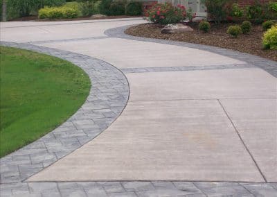 Curved driveway to the house with nicely trimmed sides